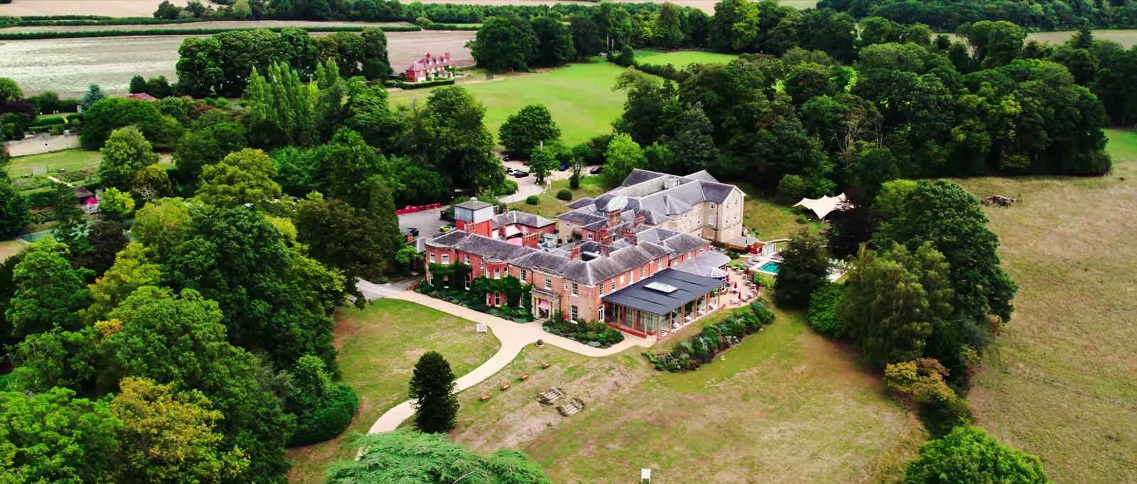An aerial view of the red-brick house and its grounds among woods and fields near Newbury