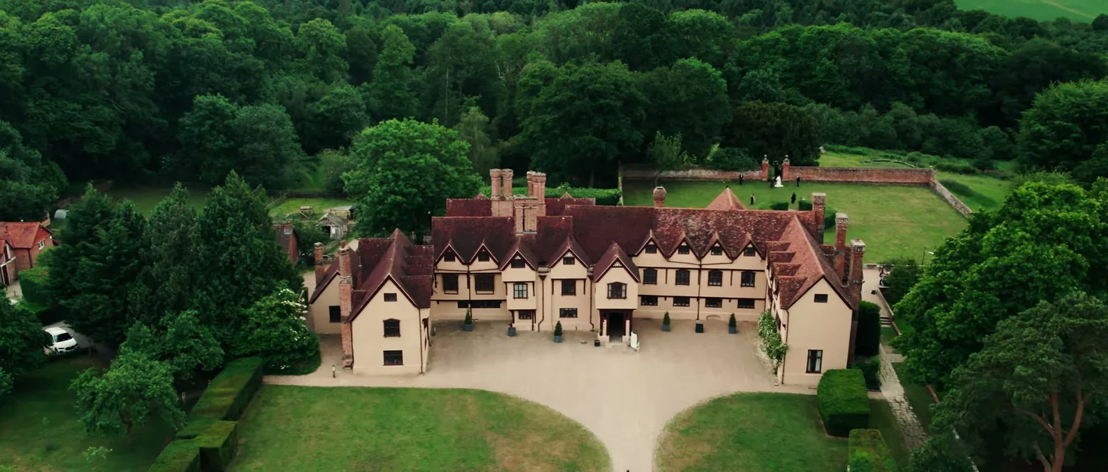 An aerial view of the timber-framed manor house at Ufton Court with its gravel forecourt, walled lawn and surrounding woodland