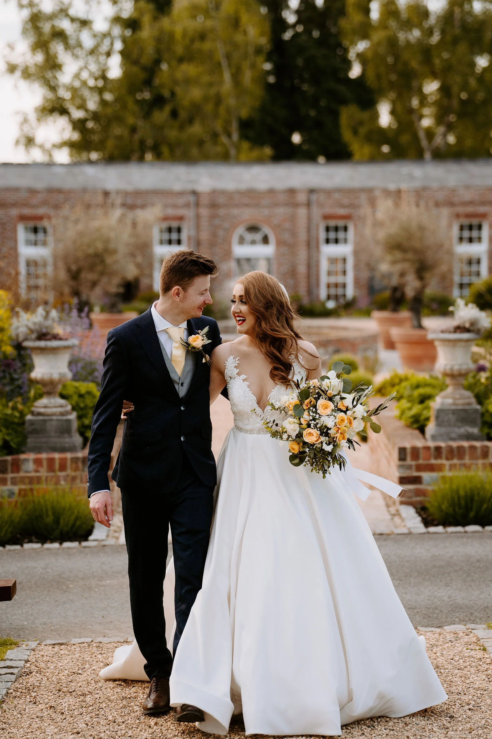 Joyful confetti exit for Danielle and Alex outside the ceremony barn at Wasing Park