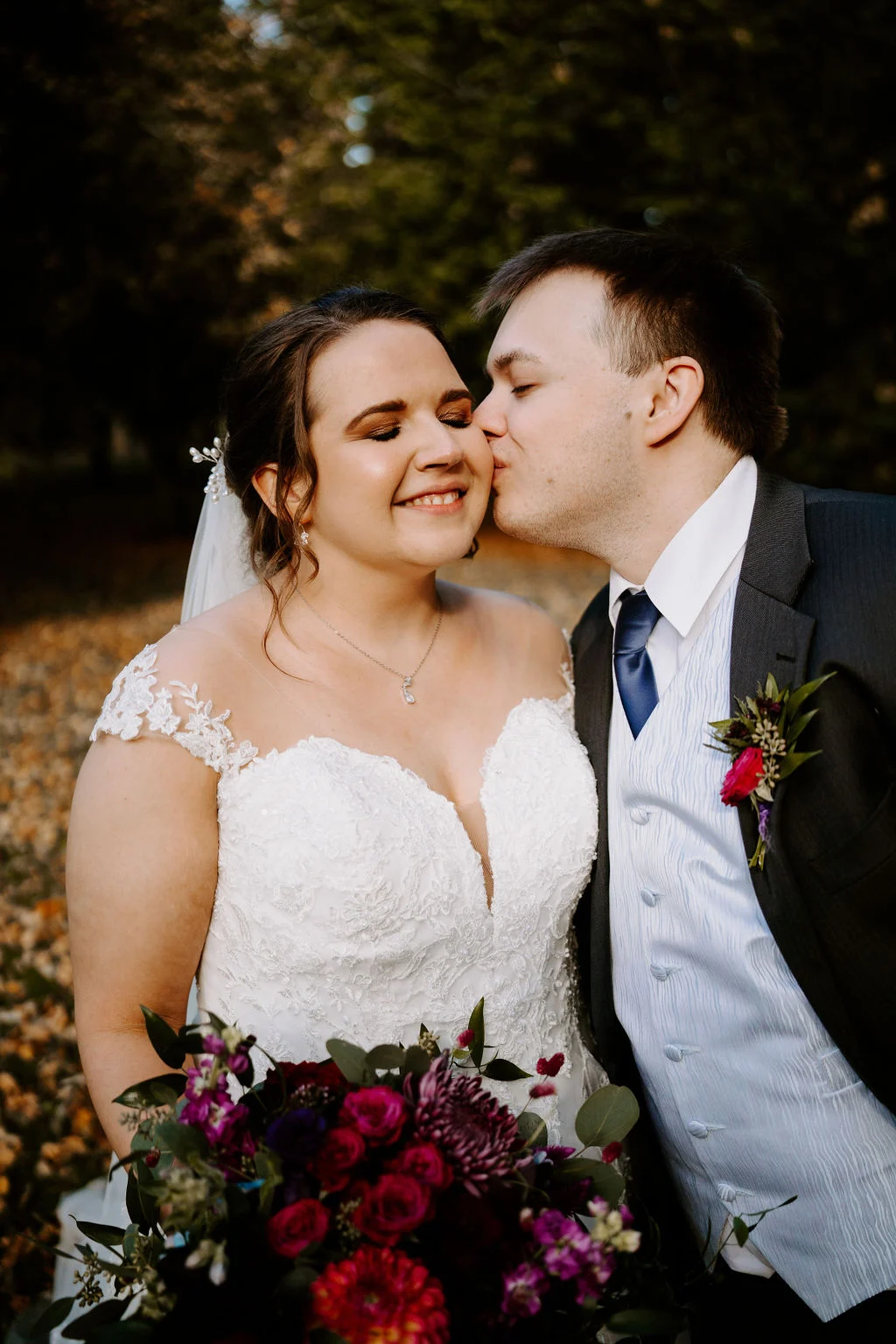 Tom kissing Charlotte on the cheek during a garden portrait at Draycote Hotel