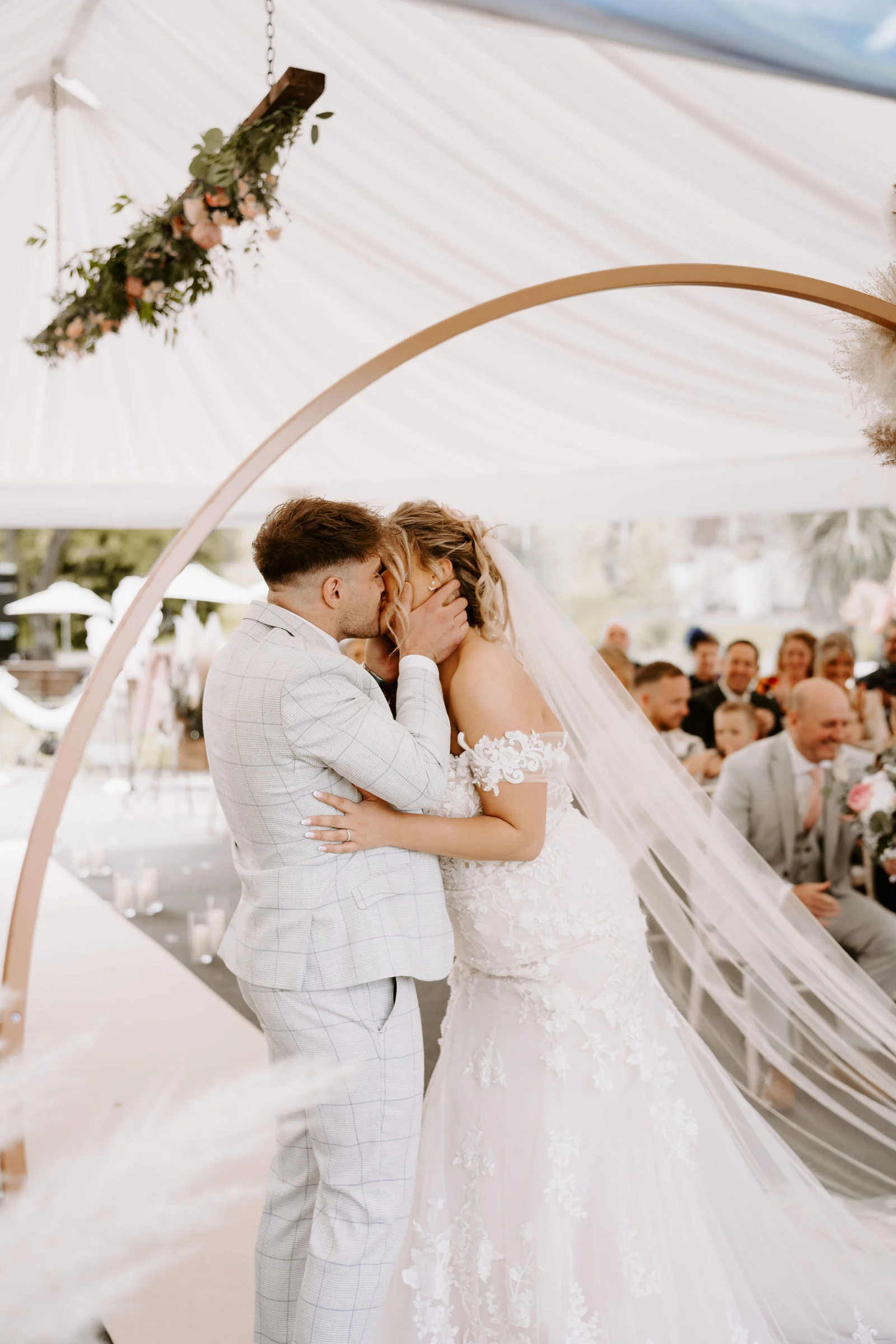 Happy newlywed couple celebrating with drinks by the water