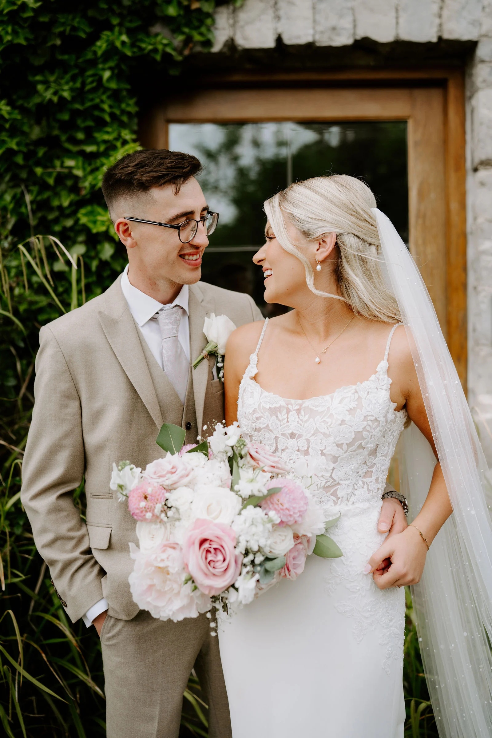 Romantic bride and groom embrace in the coastal fields of Llantwit Major