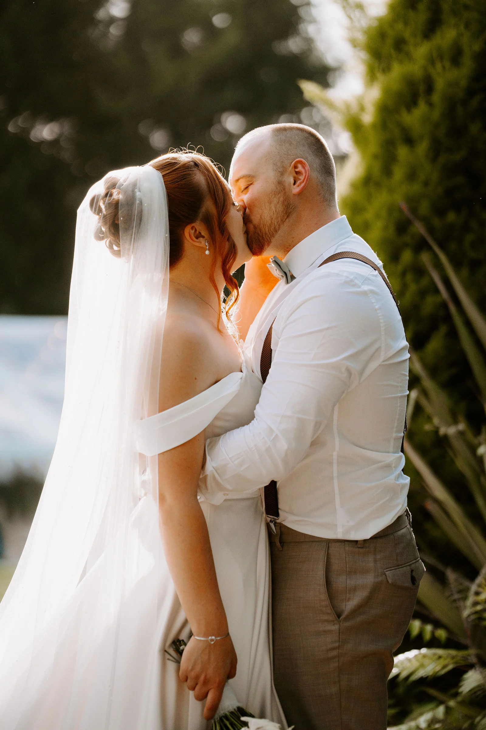 Bride and groom smiling during garden stroll at The Old Rectory Clinic in Pencoed