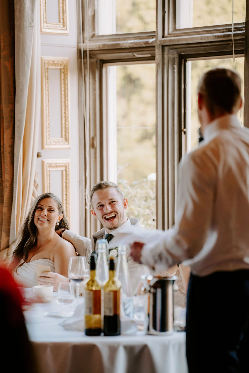 Natasha and a guest listening to a speech at the wedding breakfast
