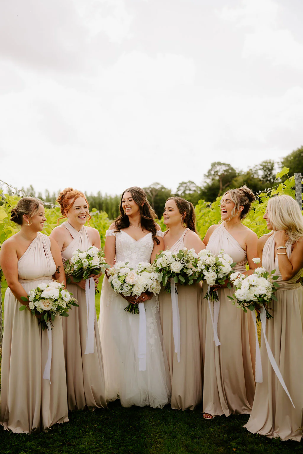 Bethan and James smiling together during their drinks reception at Llanerch Vineyard