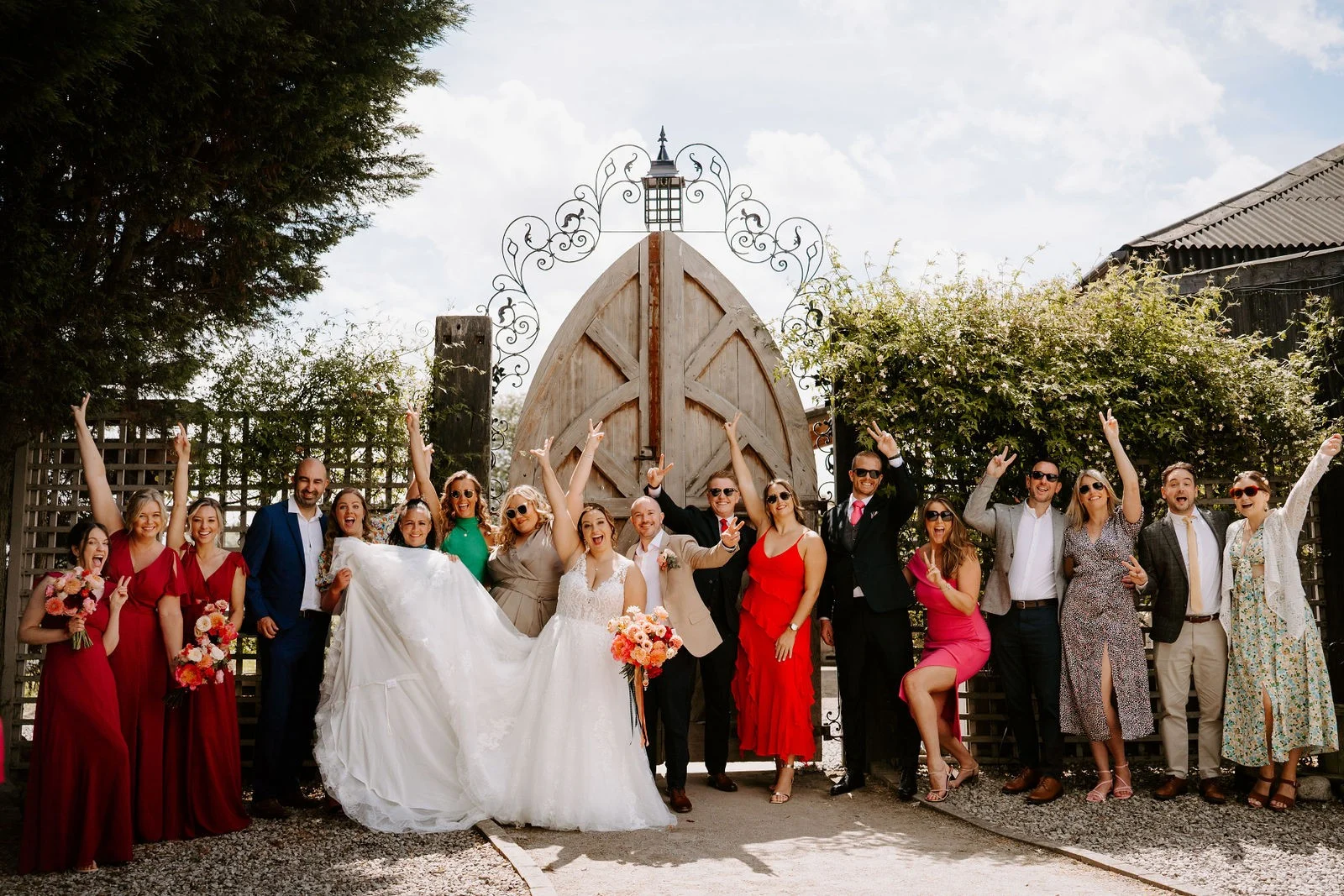 Lauren and Jon celebrating with their wedding party outside the White House at Alcumlow Wedding Barn