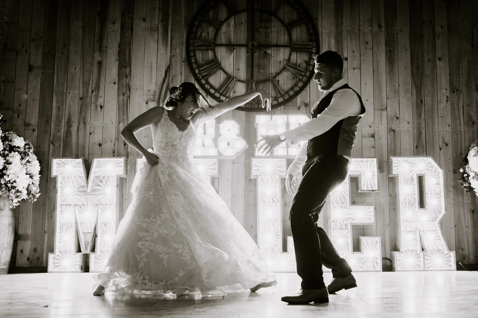 Martha and Harry sharing their first dance beneath the barn lights at Alcumlow Wedding Barn