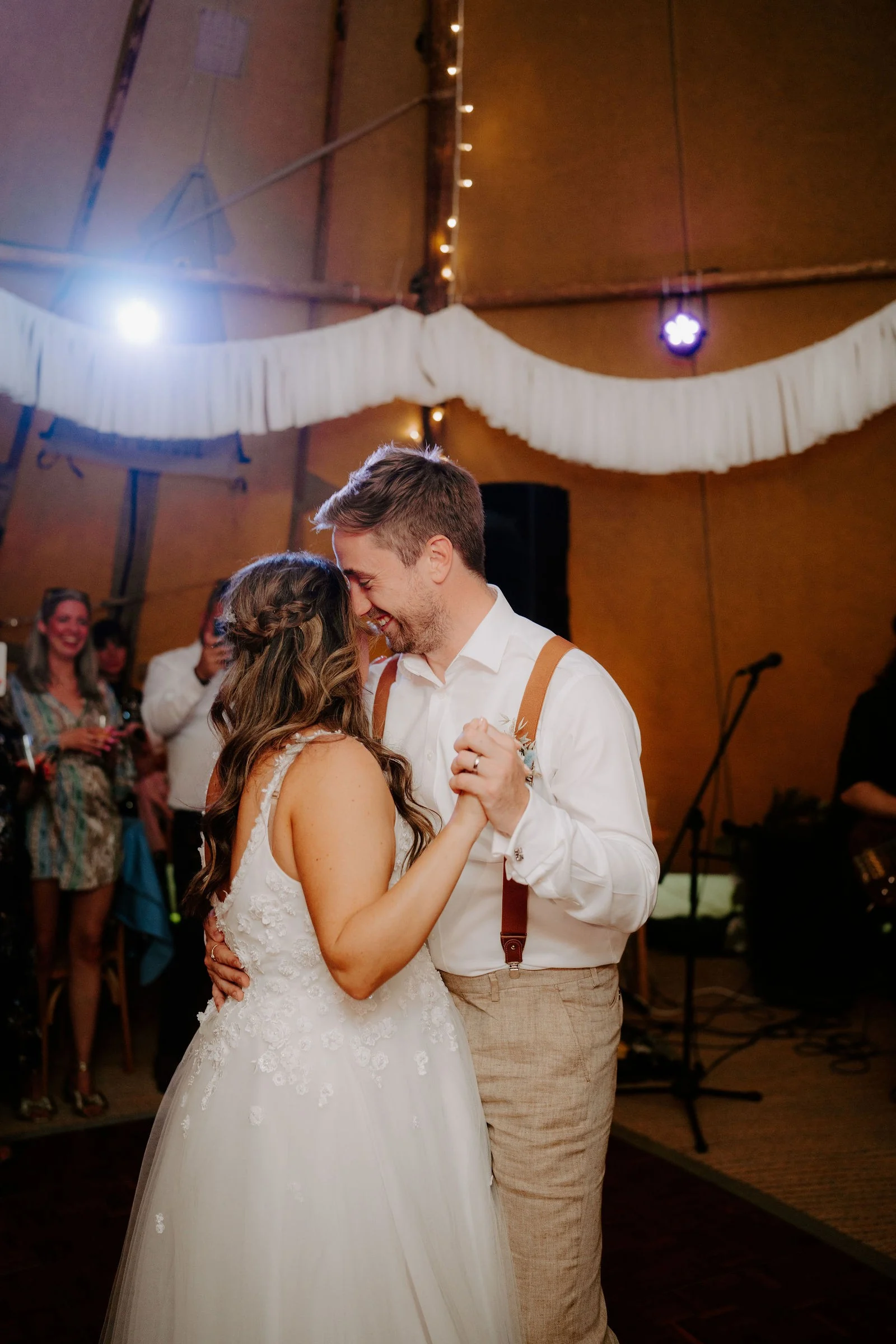 Rebecca and Sam sharing their first dance under warm marquee lights at Duddon Mill Farm
