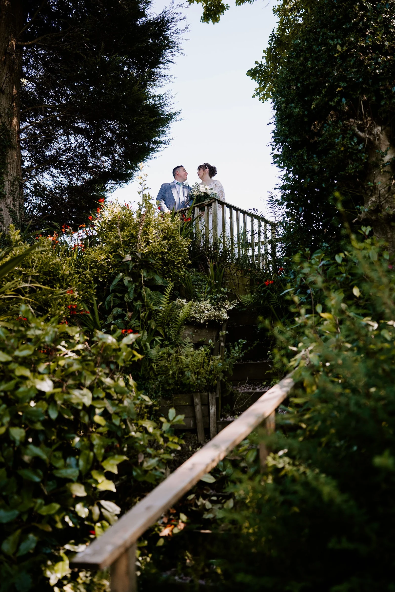 Leanne and Terry together at the top of the garden steps beneath a pergola at Hilltop Country House