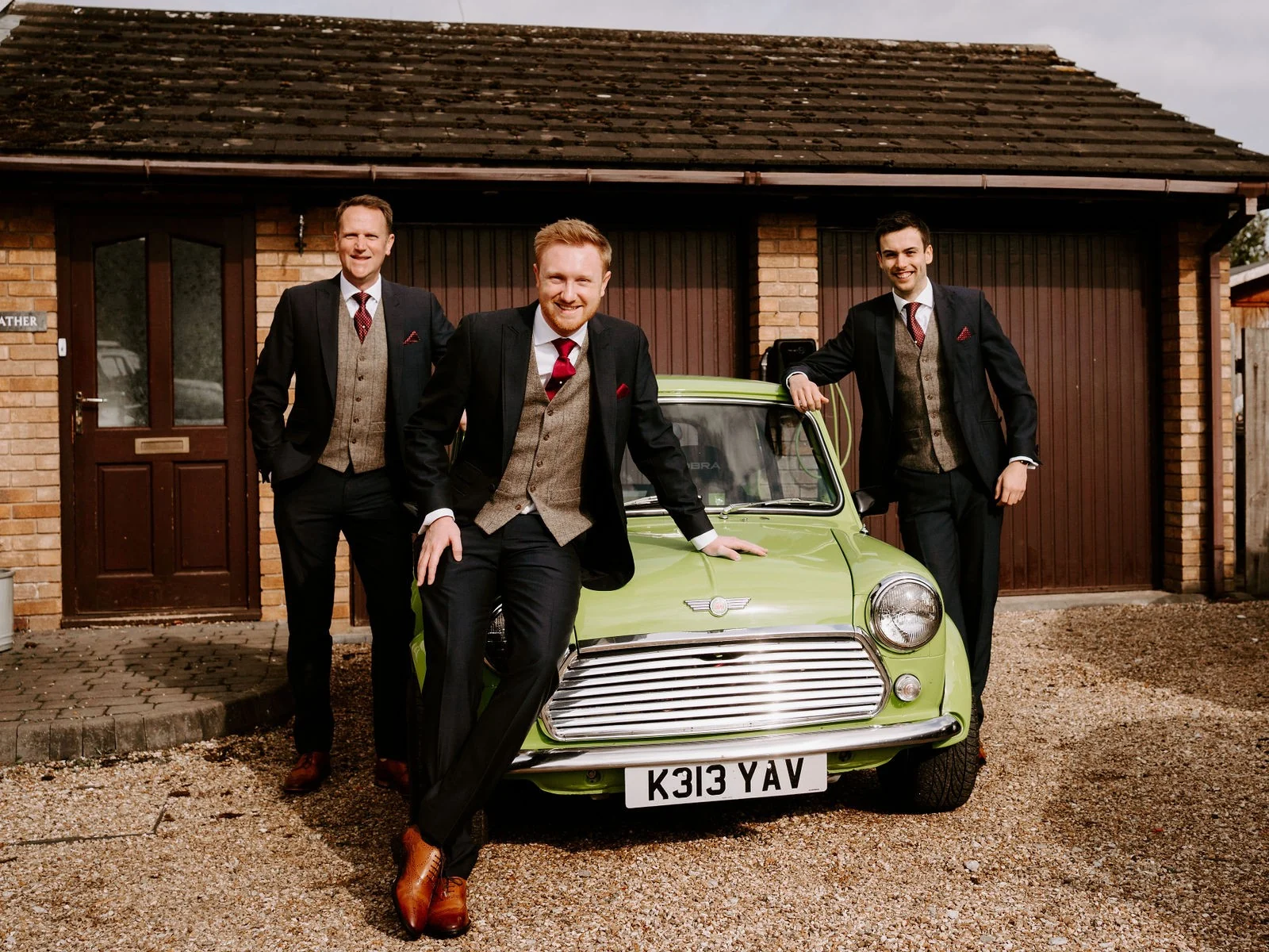 Mikey and his groomsmen beside a green Mini outside the manor at Inglewood Manor