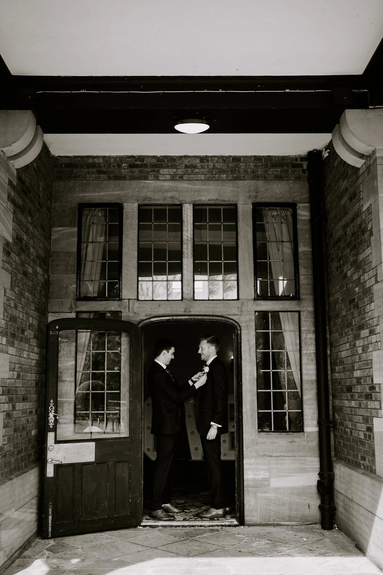 Gabi and Mikey kissing in the glass panelled doorway at Inglewood Manor
