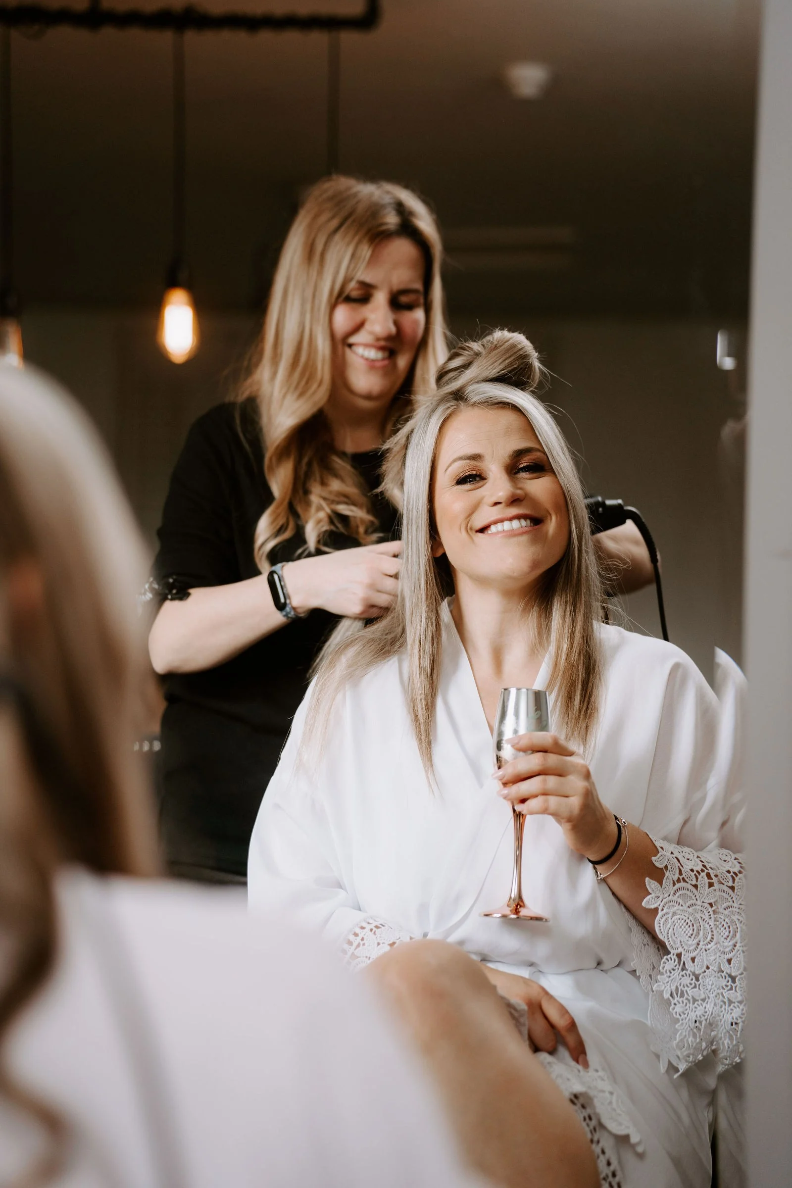 Melissa smiling while her hair is styled before the wedding at Larkspur Lodge