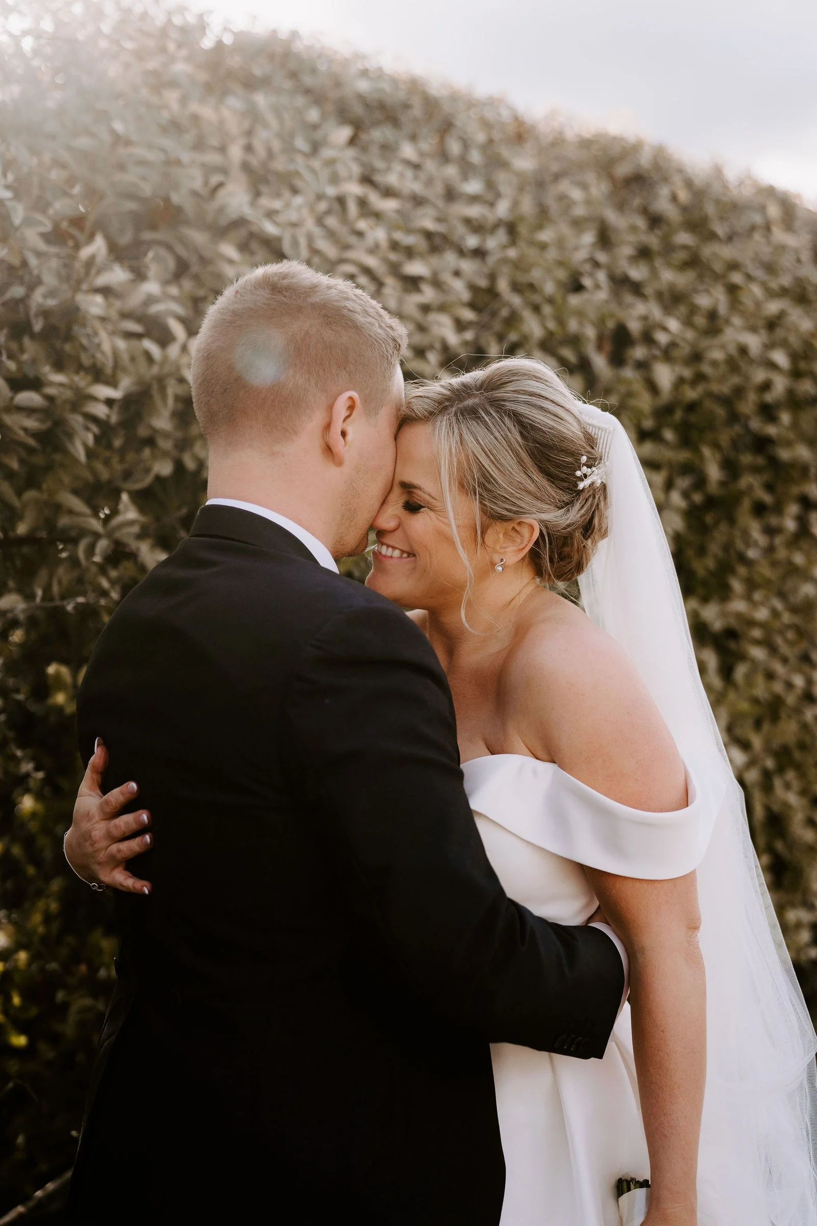 Melissa and Oliver kissing in the garden at Larkspur Lodge