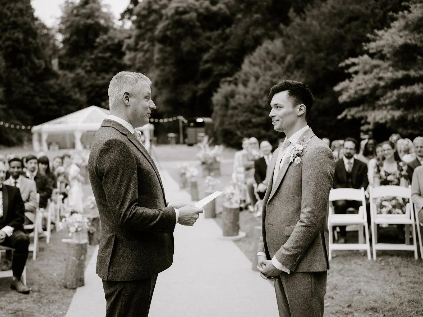 Sydney and Luke exchanging outdoor wedding vows in a secluded woodland clearing under ancient trees at Port Eliot Estate