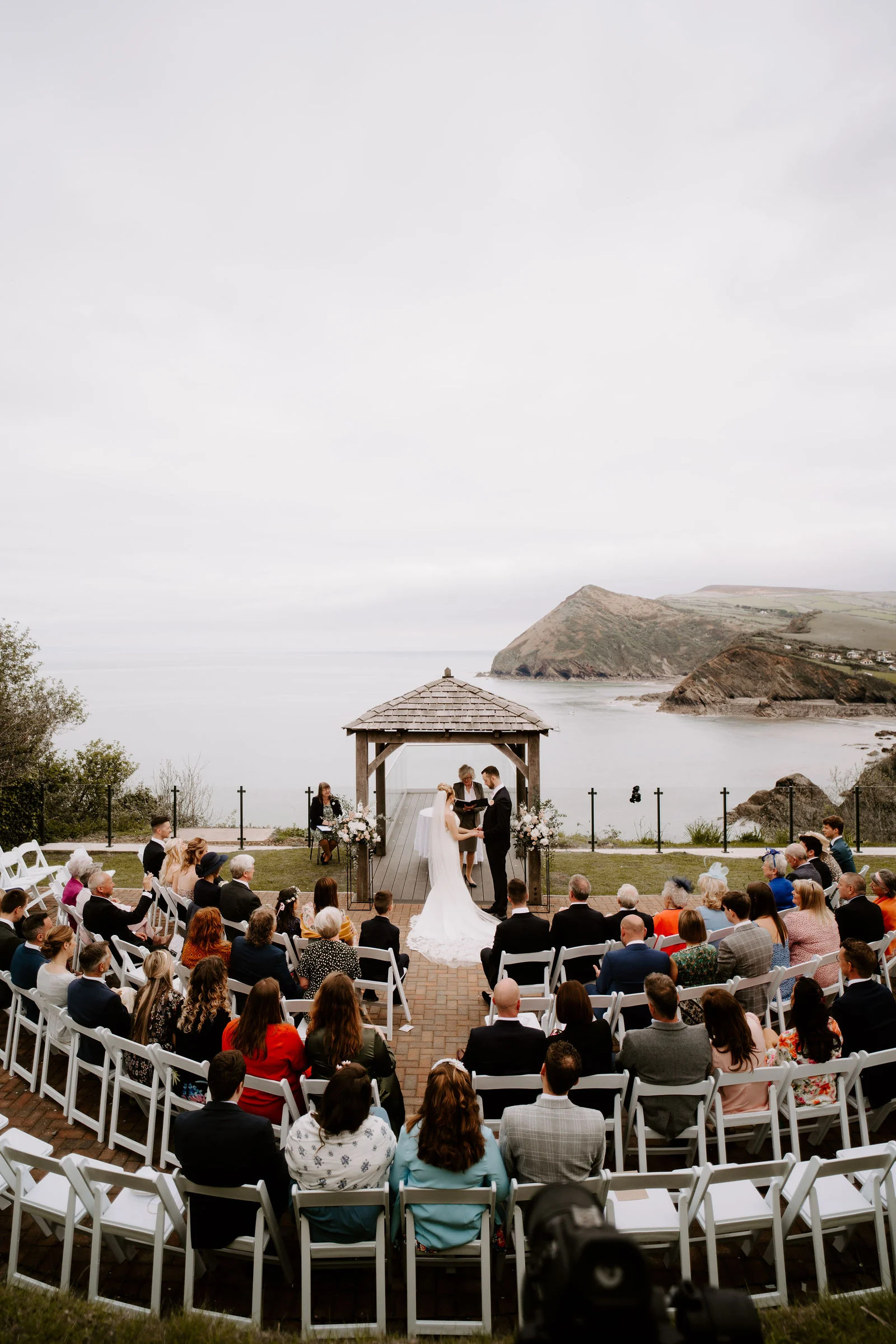 Gareth and Georgina exchanging outdoor ceremony vows in the clifftop gazebo overlooking the Atlantic Ocean at Sandy Cove Hotel in North Devon