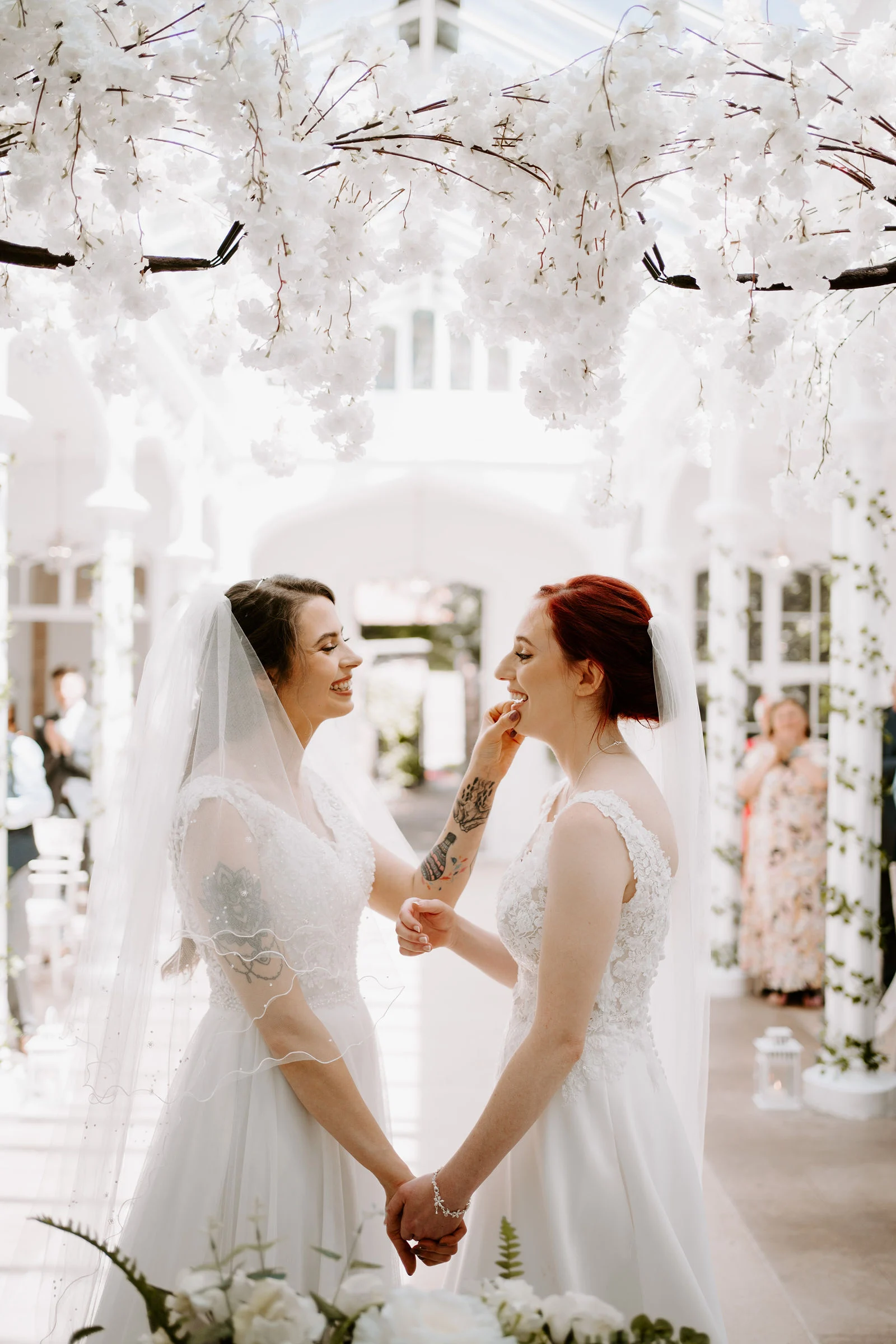 Jodie and Natalie laughing and holding hands at the altar after being pronounced newlyweds in the Orangery