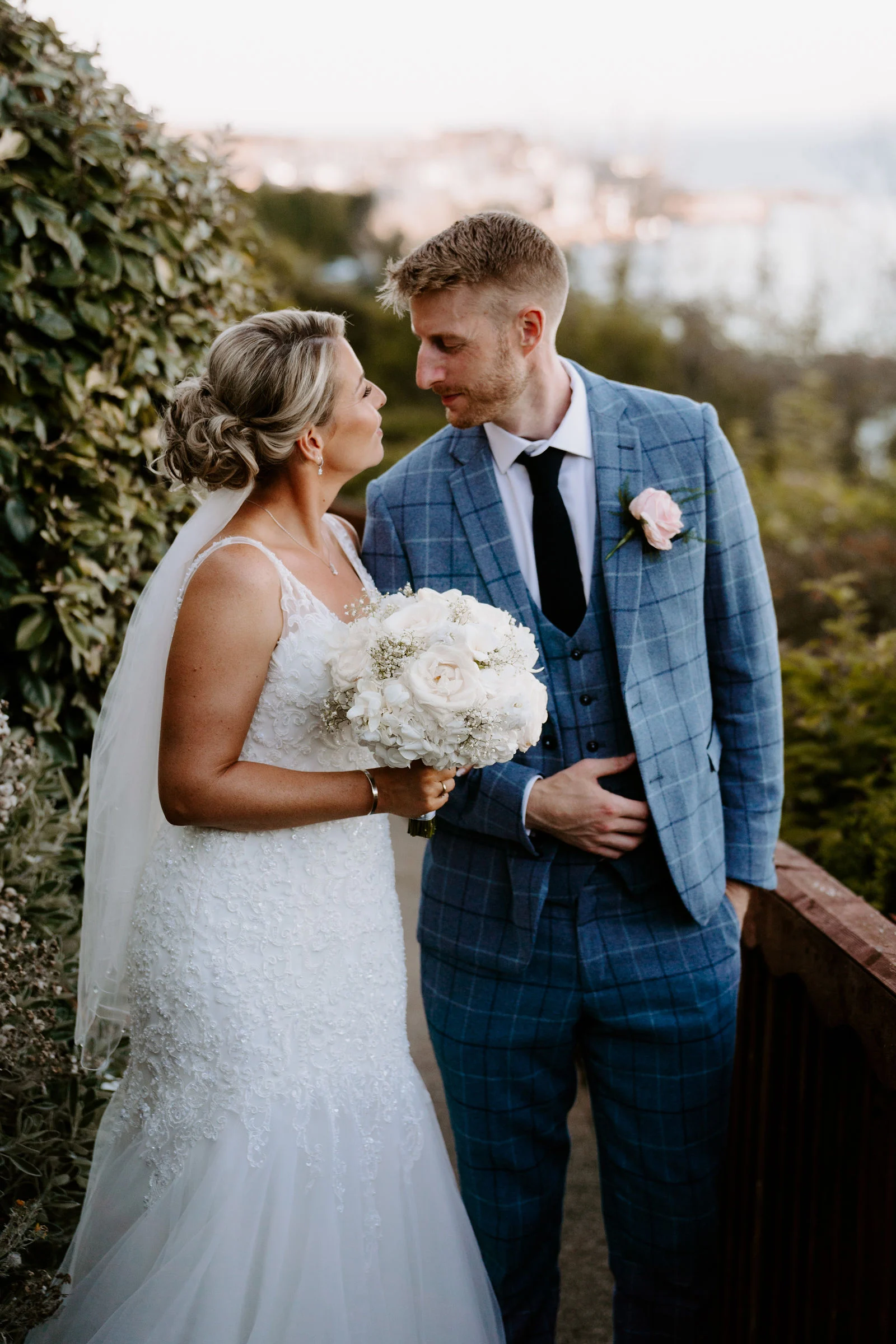 Sarah and Rob embracing during golden hour sunset on the coastal headland path