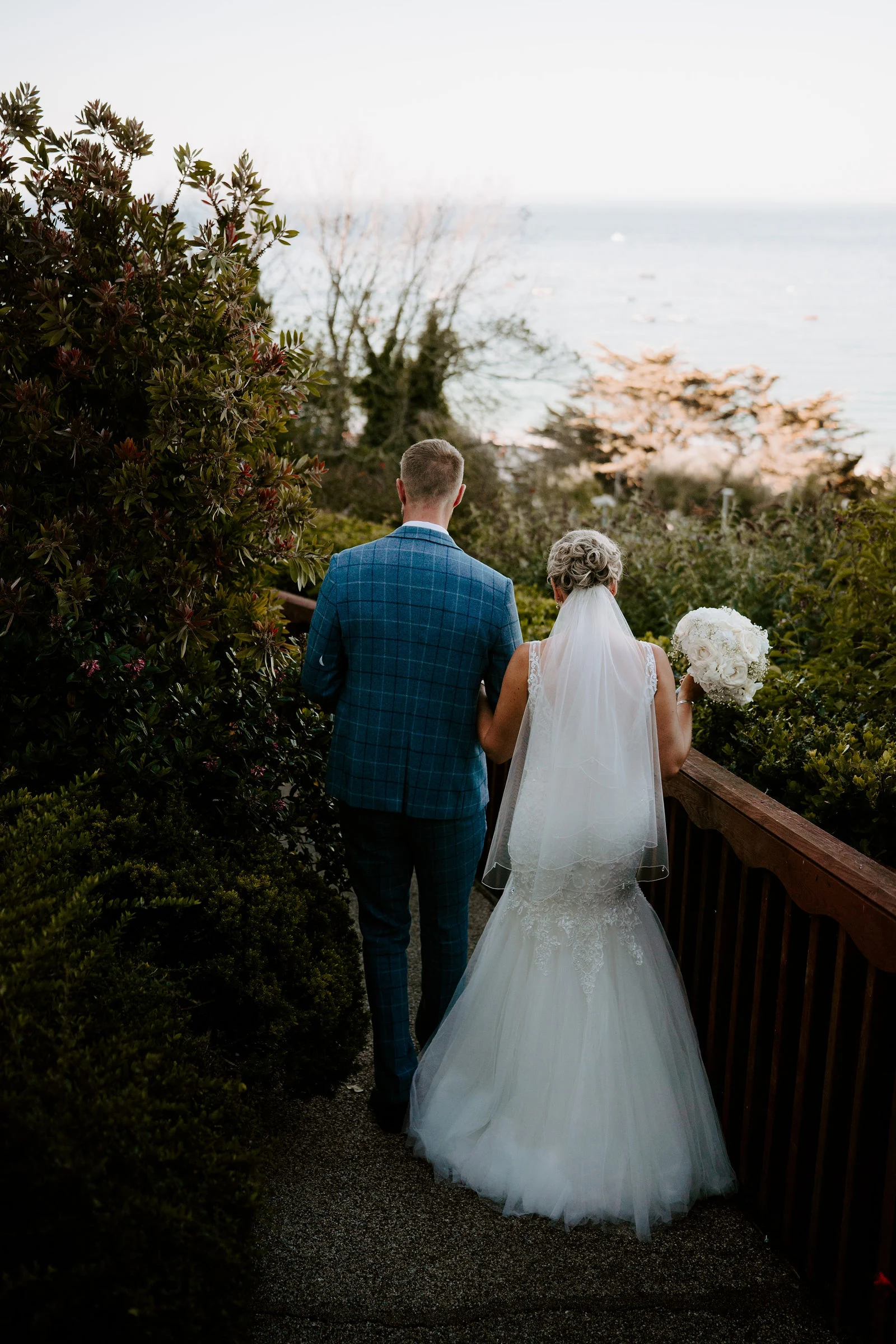Sarah and Rob walking along the clifftop coastal footpath together after sunset