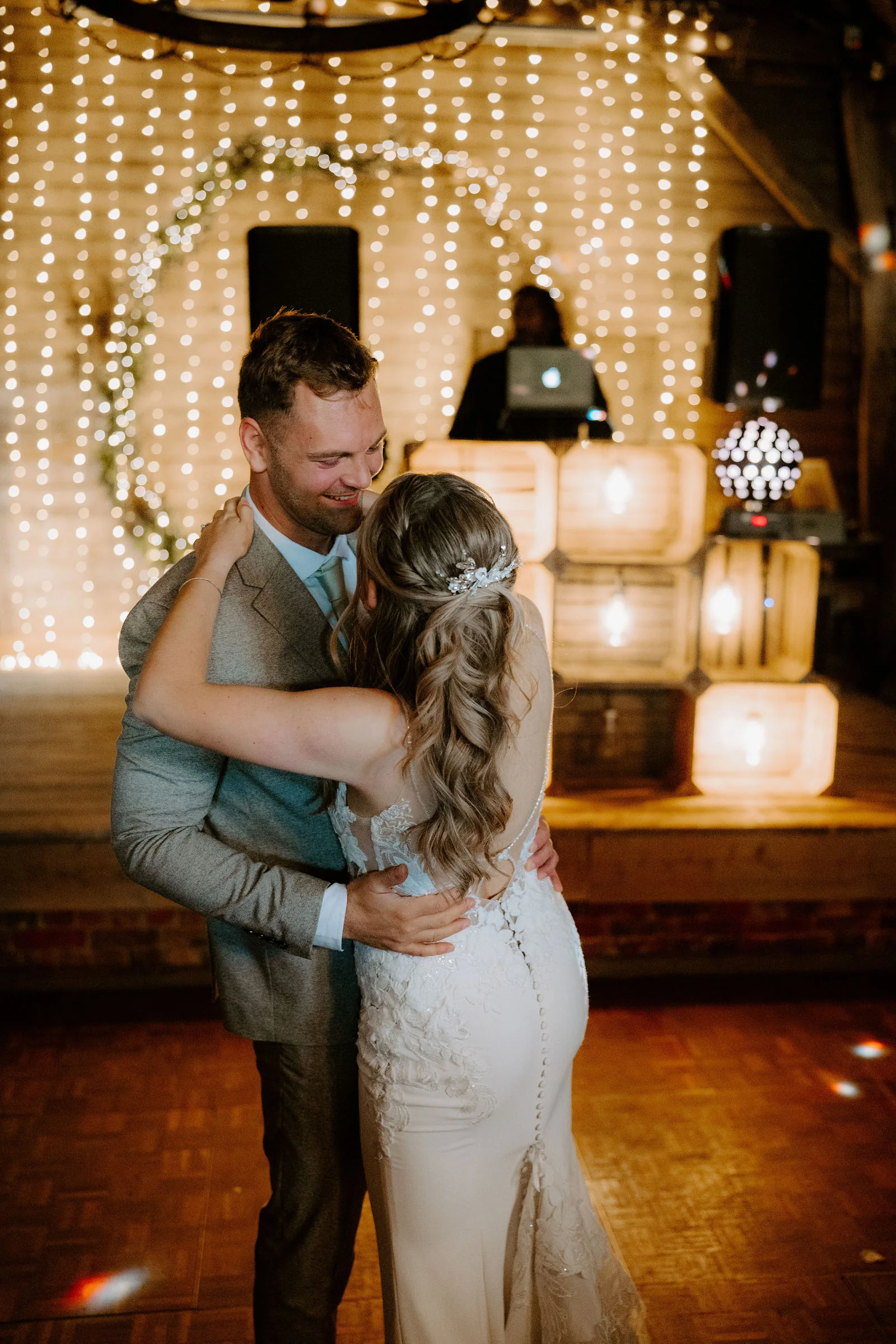 Edward and Amy's first dance before a wall of fairy lights at Bowerchalke Barn