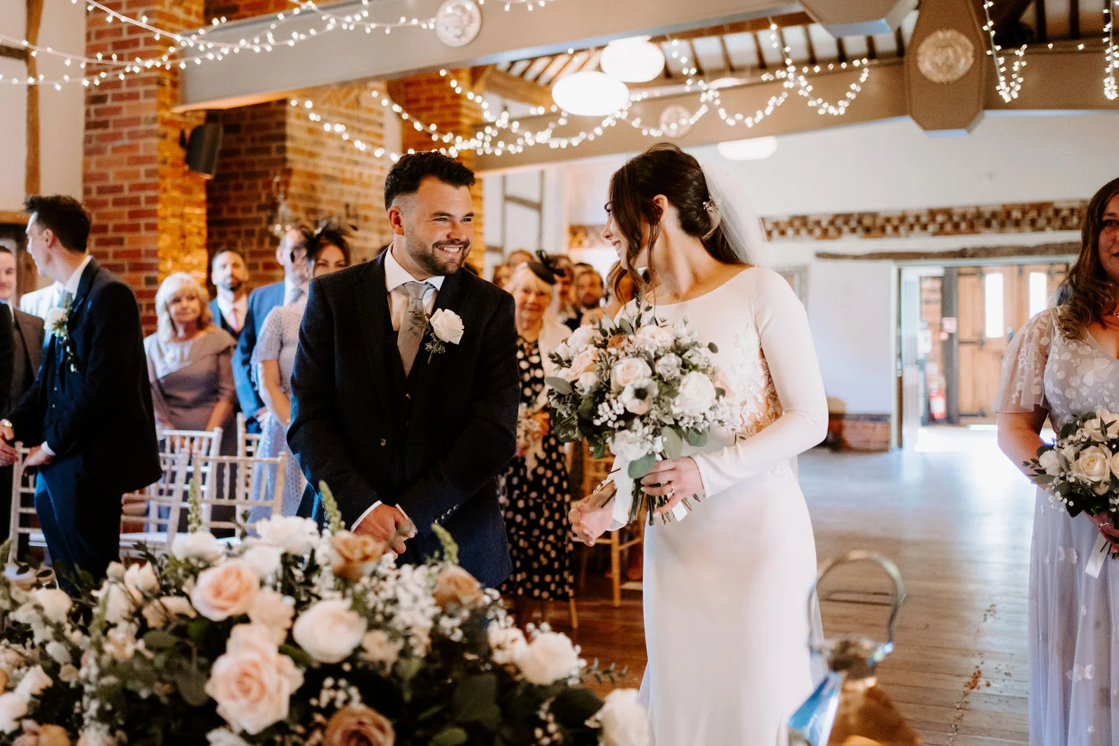 Hannah and Jamie smiling at each other during their barn ceremony at Lainston House