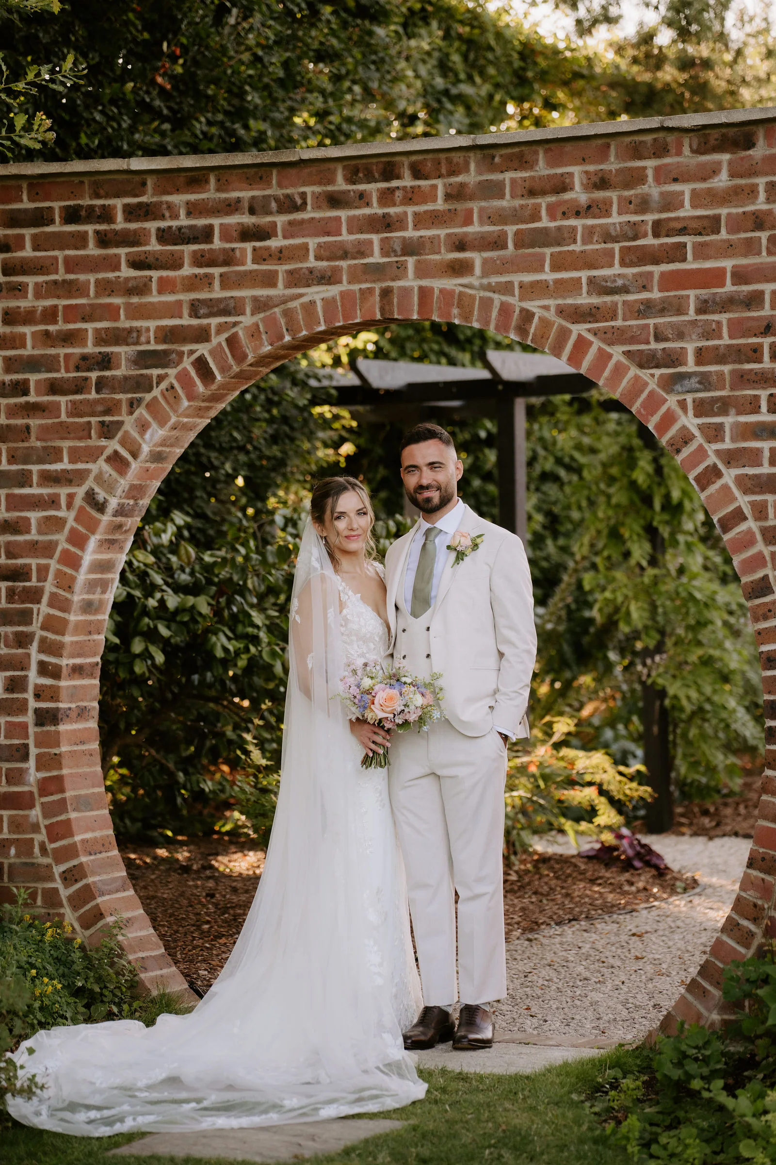 Faye and Sam together in the brick moon gate at golden hour, Parley Manor