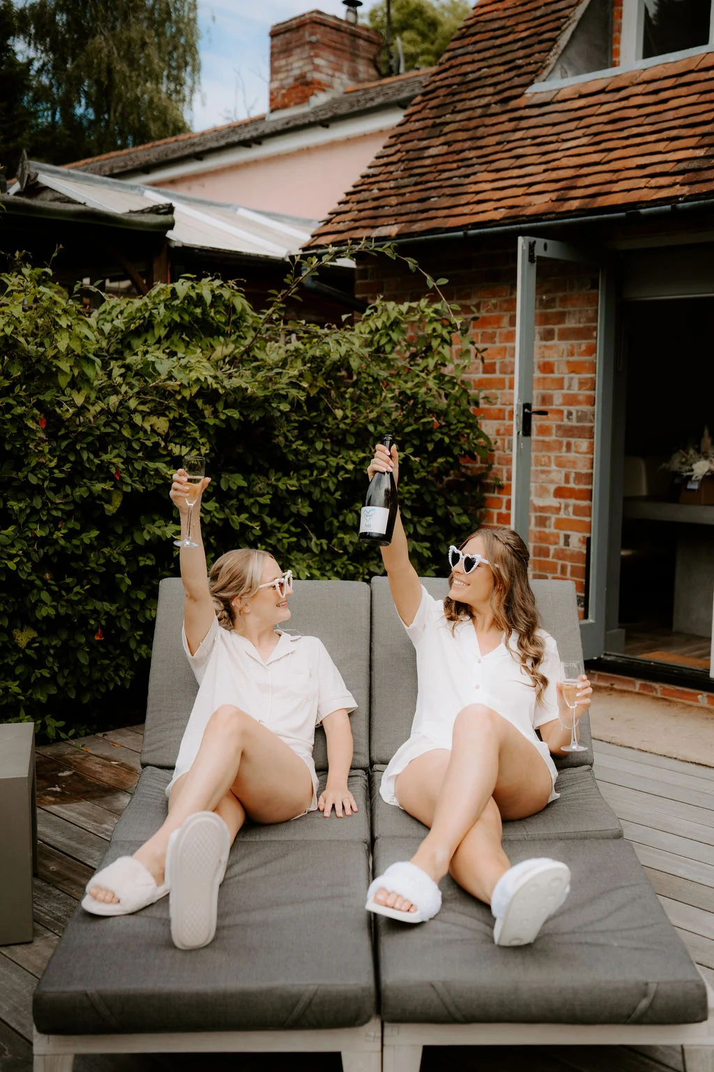 Kim and a friend sitting on outdoor loungers during wedding preparations