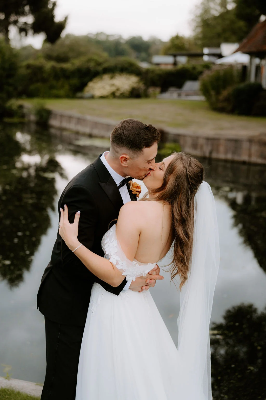 Ryan and Kim sharing a kiss beside the water at Talbooth Restaurant