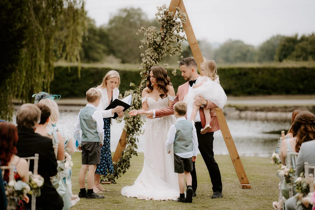 Guests raising their hands around James and Laressa during their garden celebration