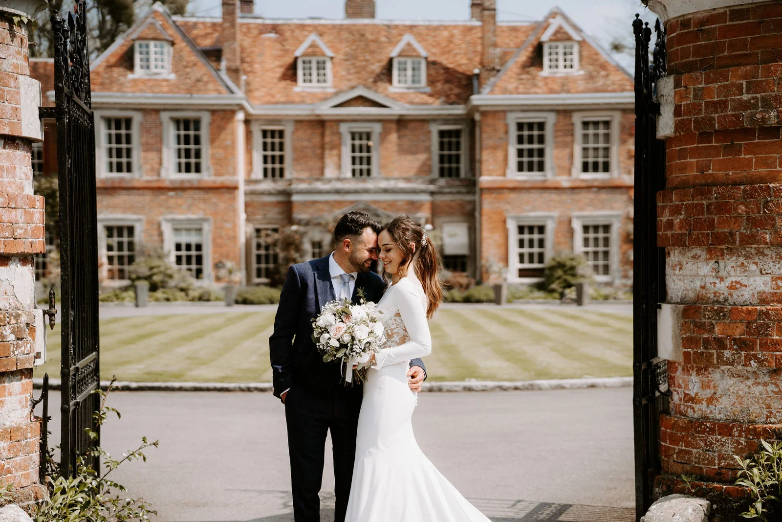 Hannah and Jamie together in the brick gateway at Lainston House in Hampshire