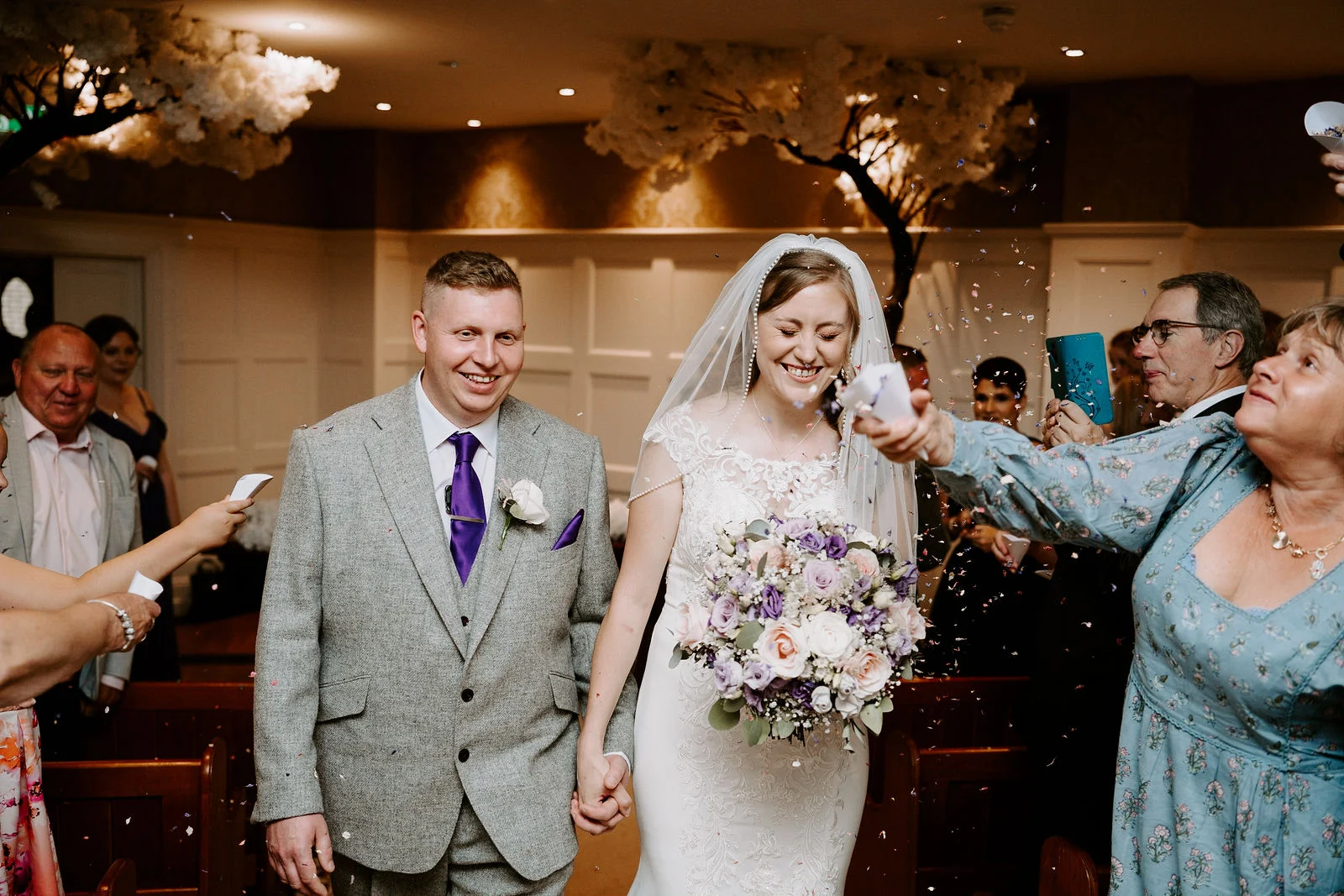 Stuart and Laura walking through confetti after their indoor ceremony at Old Thorns