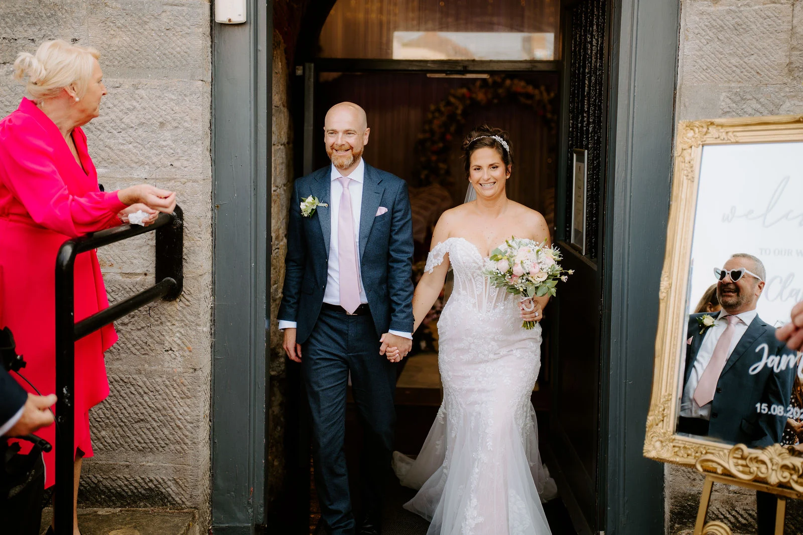 Claire and James stepping through the Square Tower doorway after their wedding ceremony