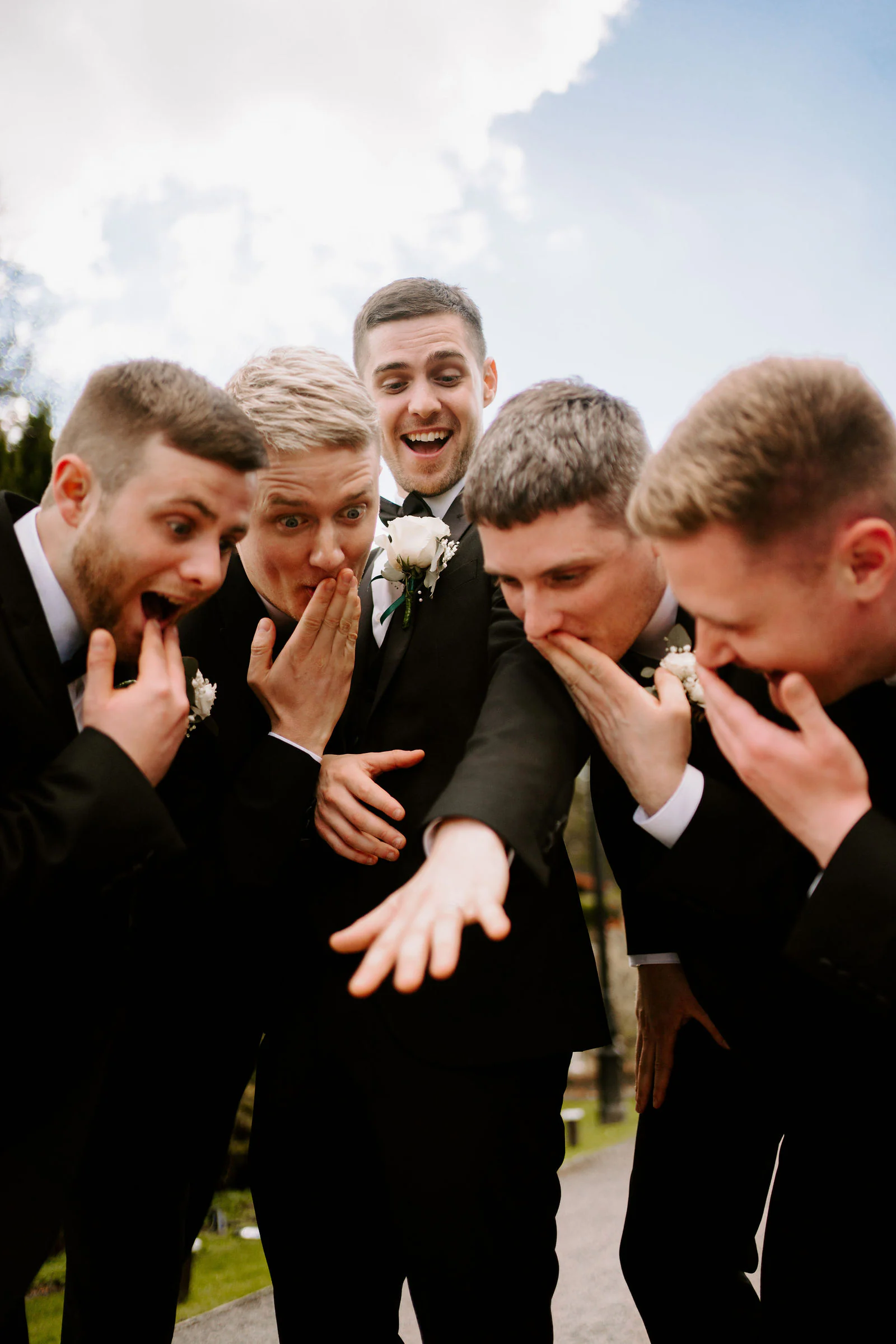 Groomsmen react with their hands over their mouths during the morning at Broadoaks Country House