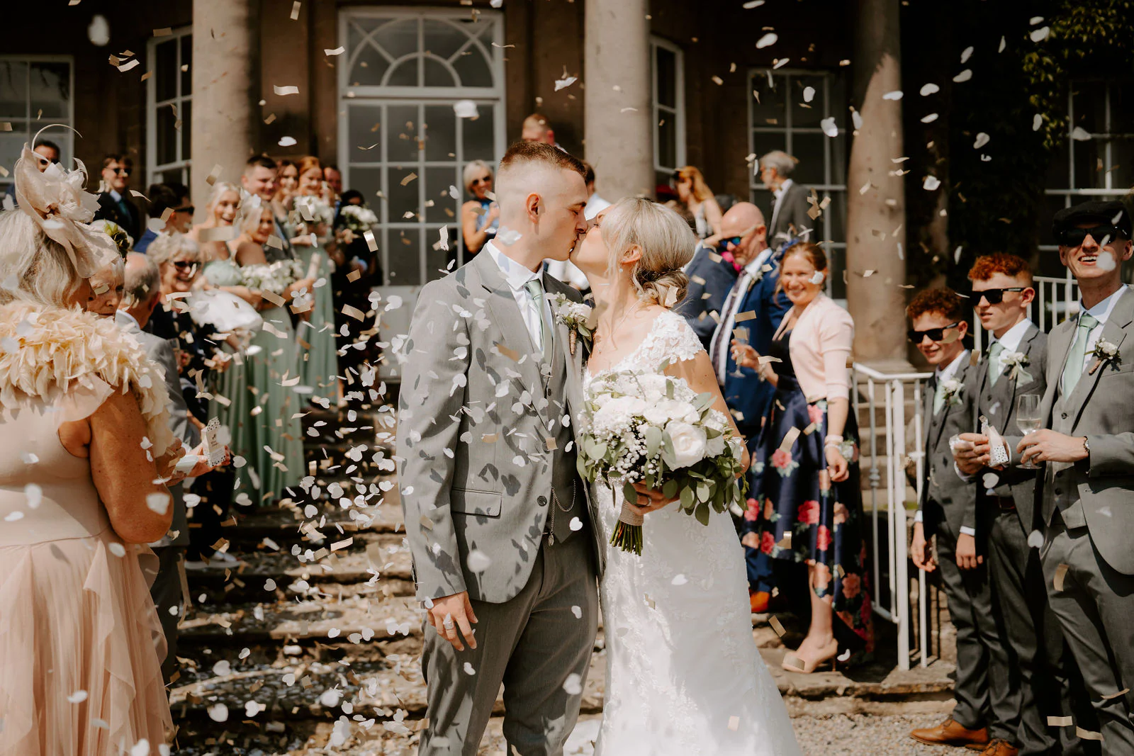Brittany and Callum kissing as guests throw confetti outside the house