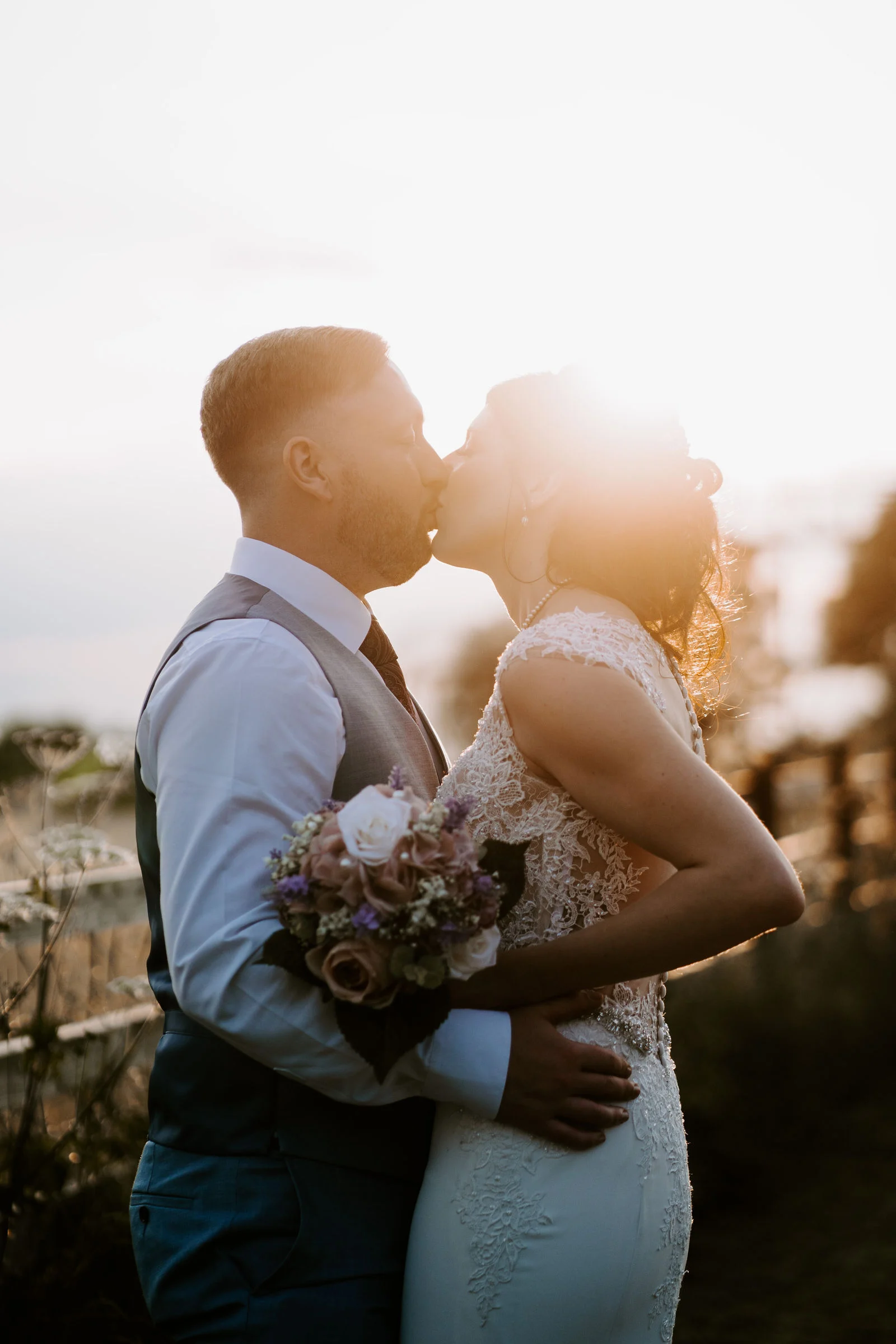 Kelly and Luke kissing in warm evening sunlight