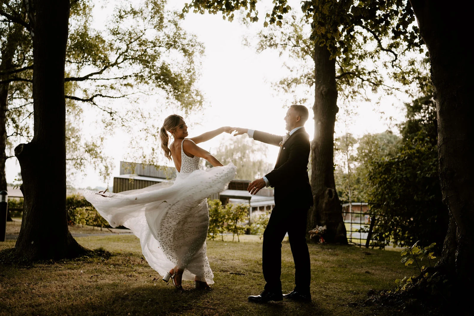 Tom spinning Emma beneath tall trees with her dress flowing