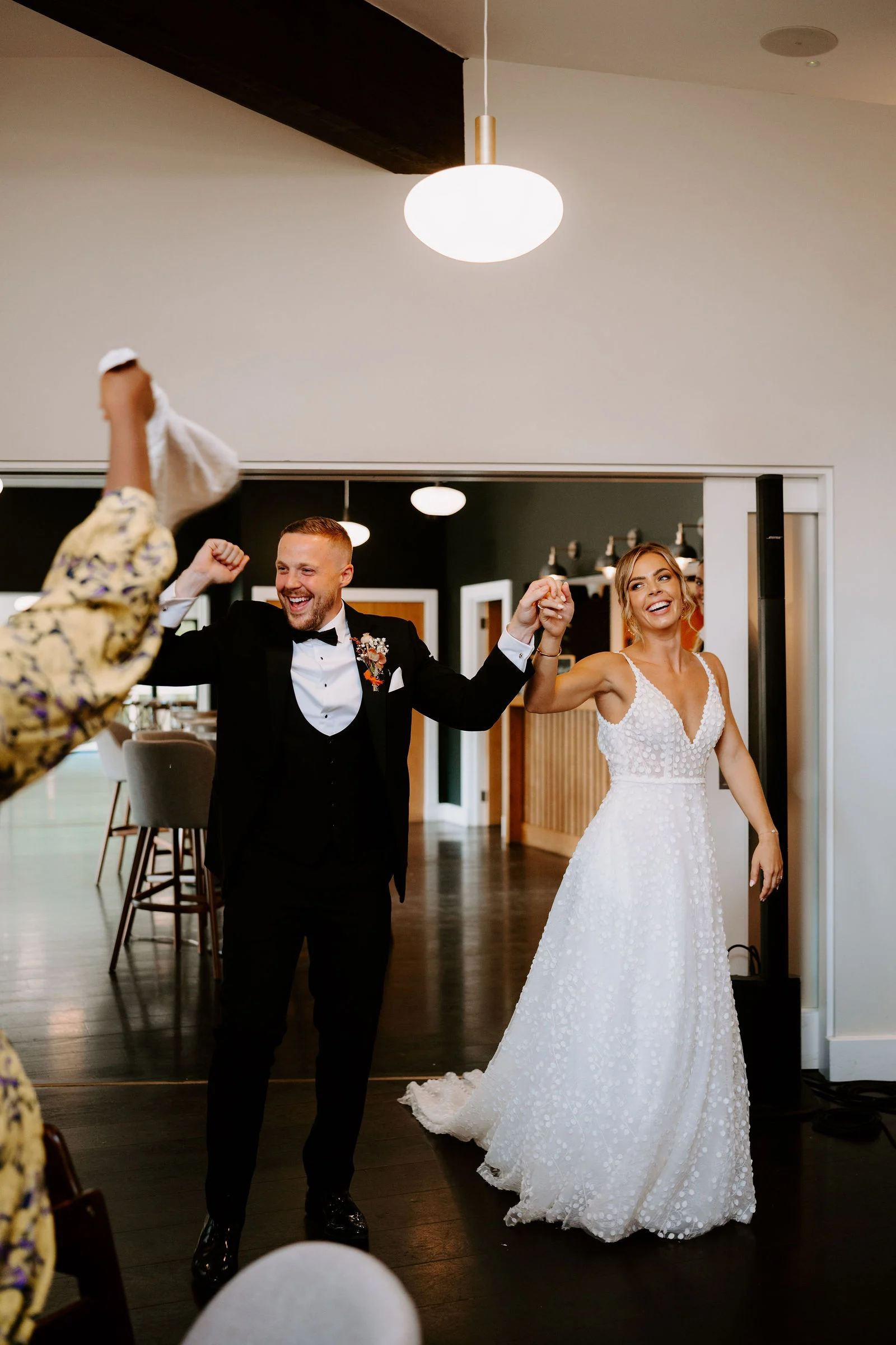 Emma and Tom entering their reception as guests cheer