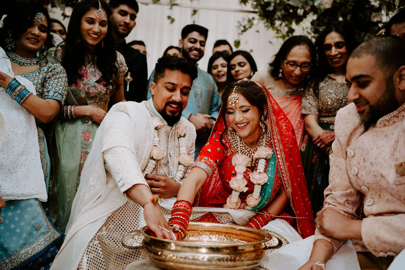 Nalini and Sanjay surrounded by smiling family during their wedding celebration