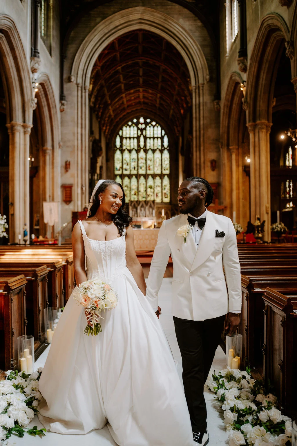Tobenna and Sapphire walking along the ornate church aisle.