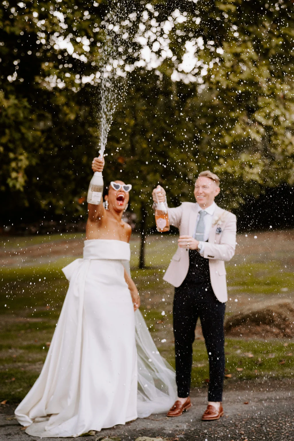 Shanice and Russel walking together beneath tall trees.