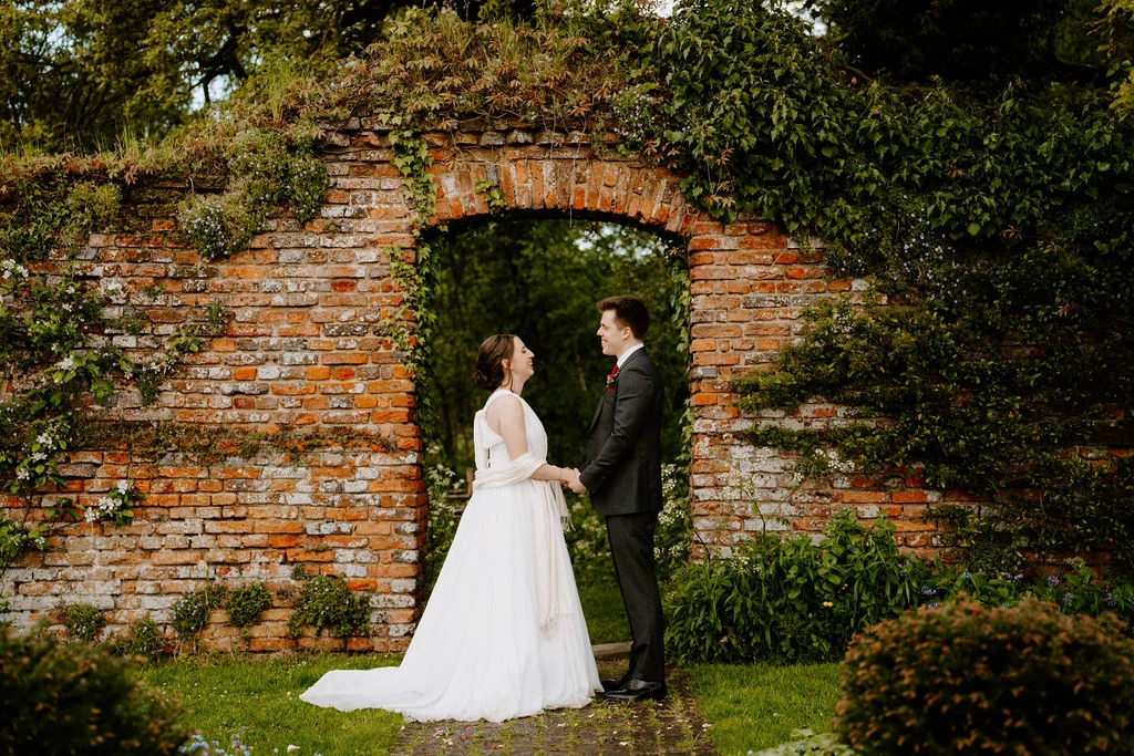 Katherine and Ryan together beneath a brick doorway.