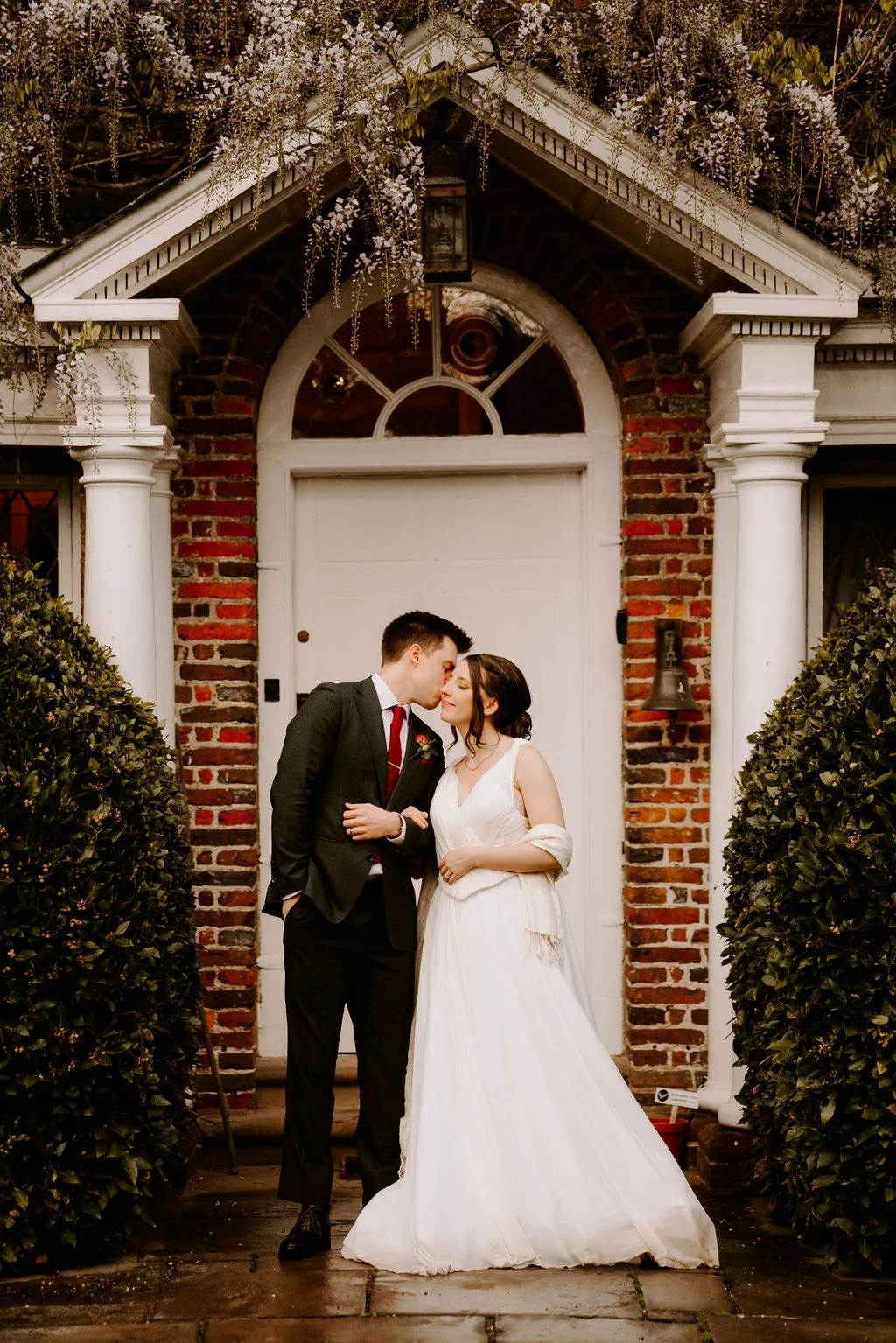 Katherine and Ryan kissing in the sheltered doorway.
