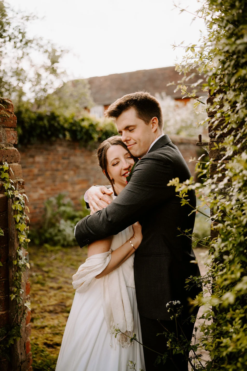 Katherine and Ryan embracing among long grasses.