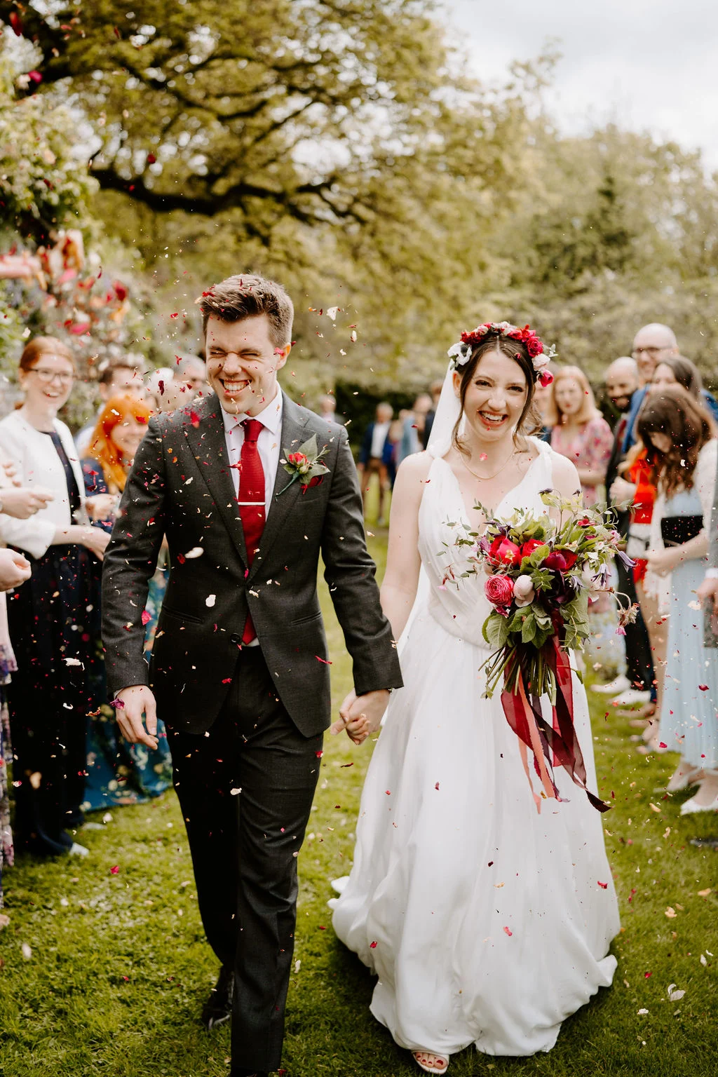 Katherine and Ryan walking through confetti with their guests.