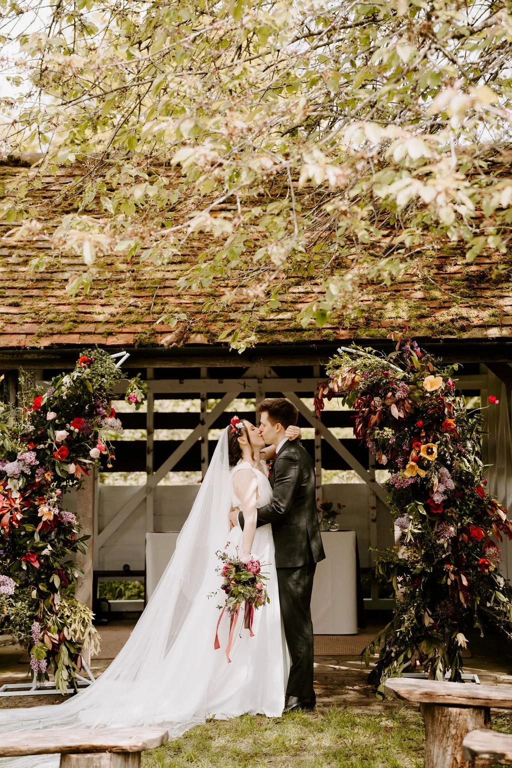 Katherine and Ryan kissing beneath a flowering tree.