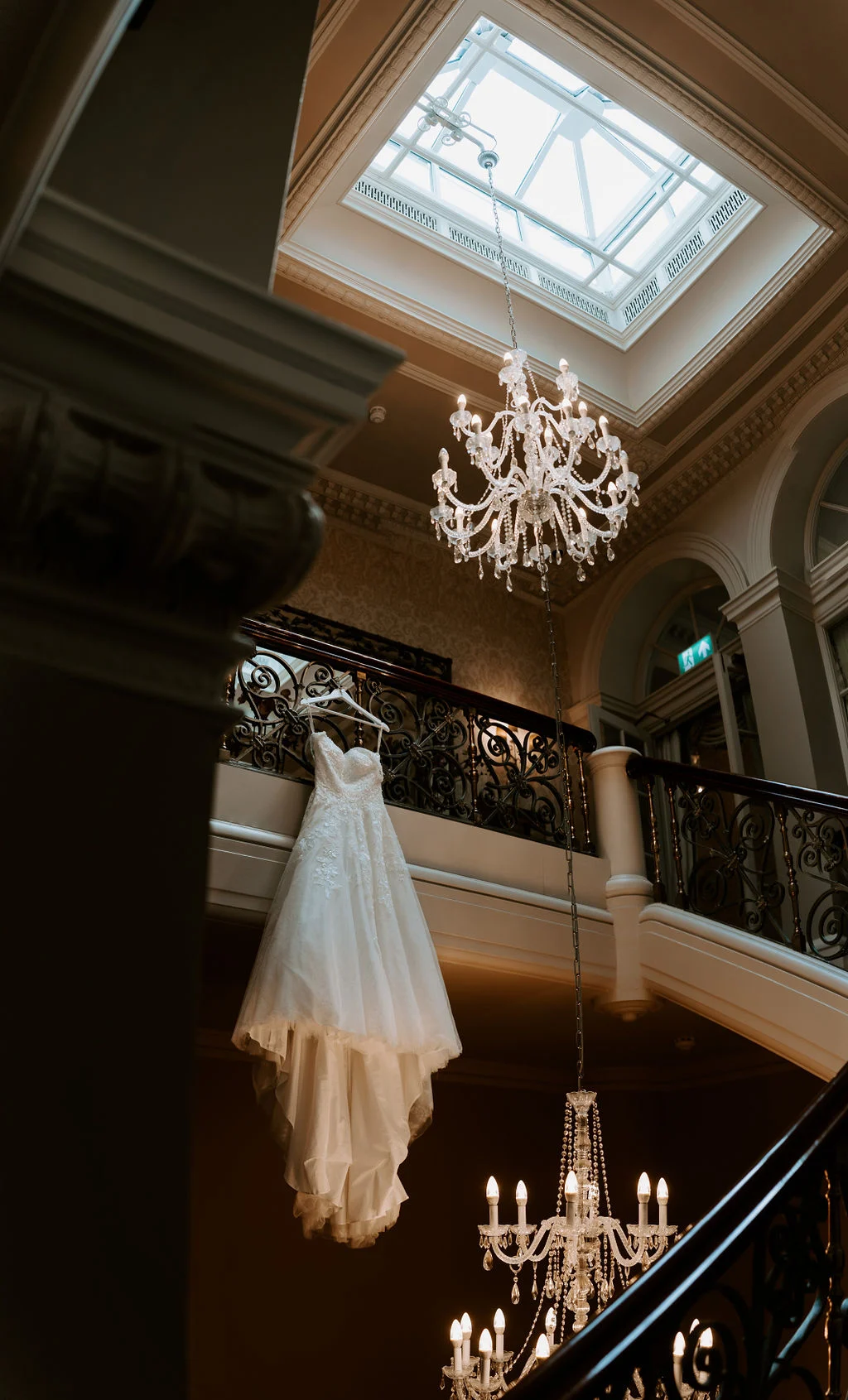 Stephanie above the chandelier on the staircase at Down Hall.