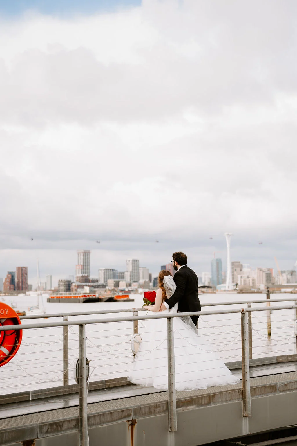 Josie and Nick beside the river with London behind them.
