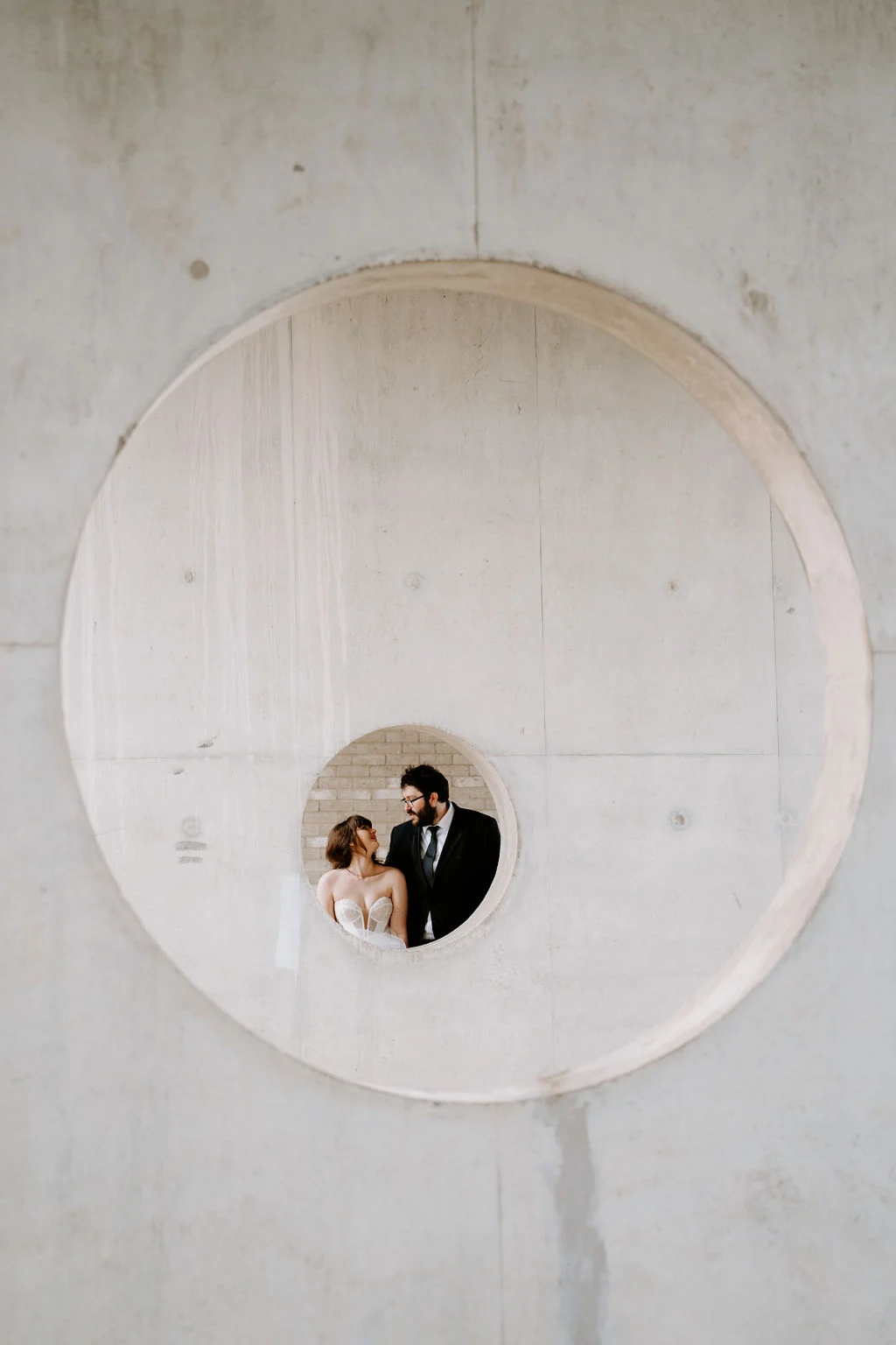Josie and Nick framed by a circular architectural opening.