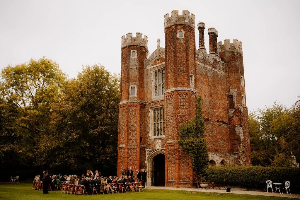Guests gathered beside the historic red-brick tower for Sophie and Jake’s wedding.
