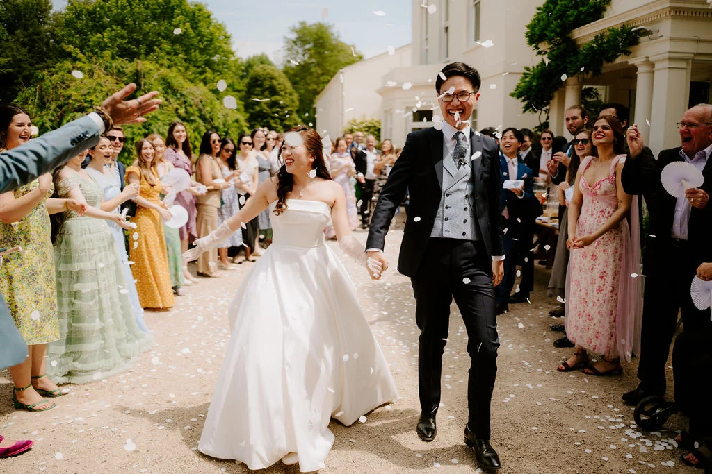 Jonathan and Tasha walking through confetti among their guests.