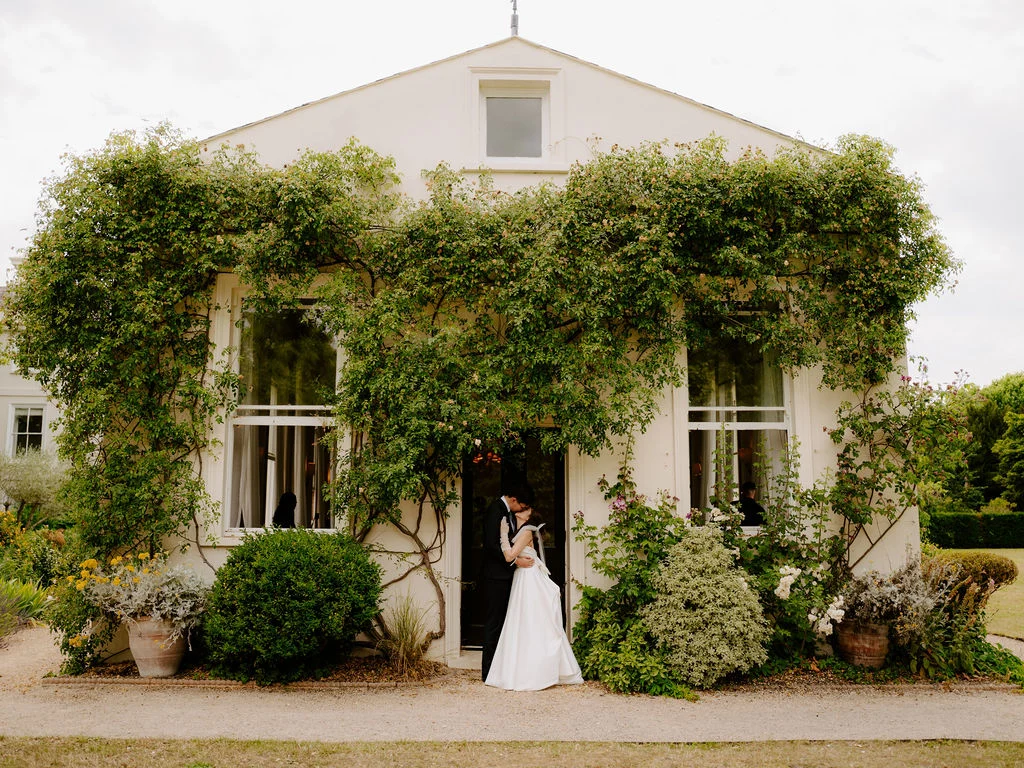 Jonathan and Tasha outside the ivy-covered house.
